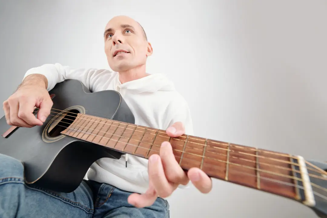 Homem de meia idade tocando violão